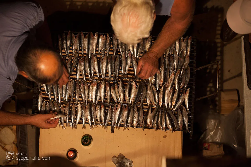 Mani che dispongono le sardine, viste dall’alto