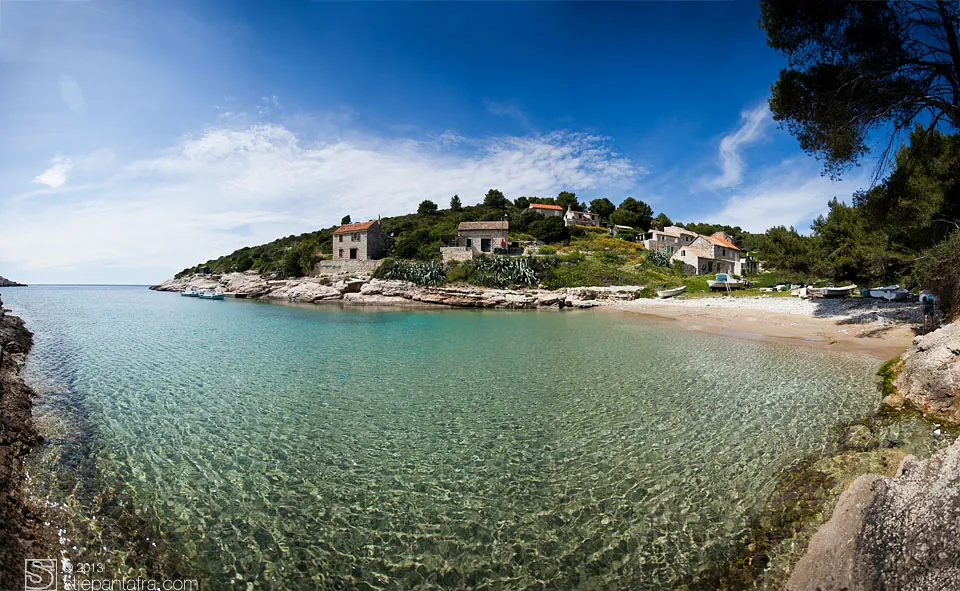 Uvala s plitkim bistrim morem i kamenom kućom